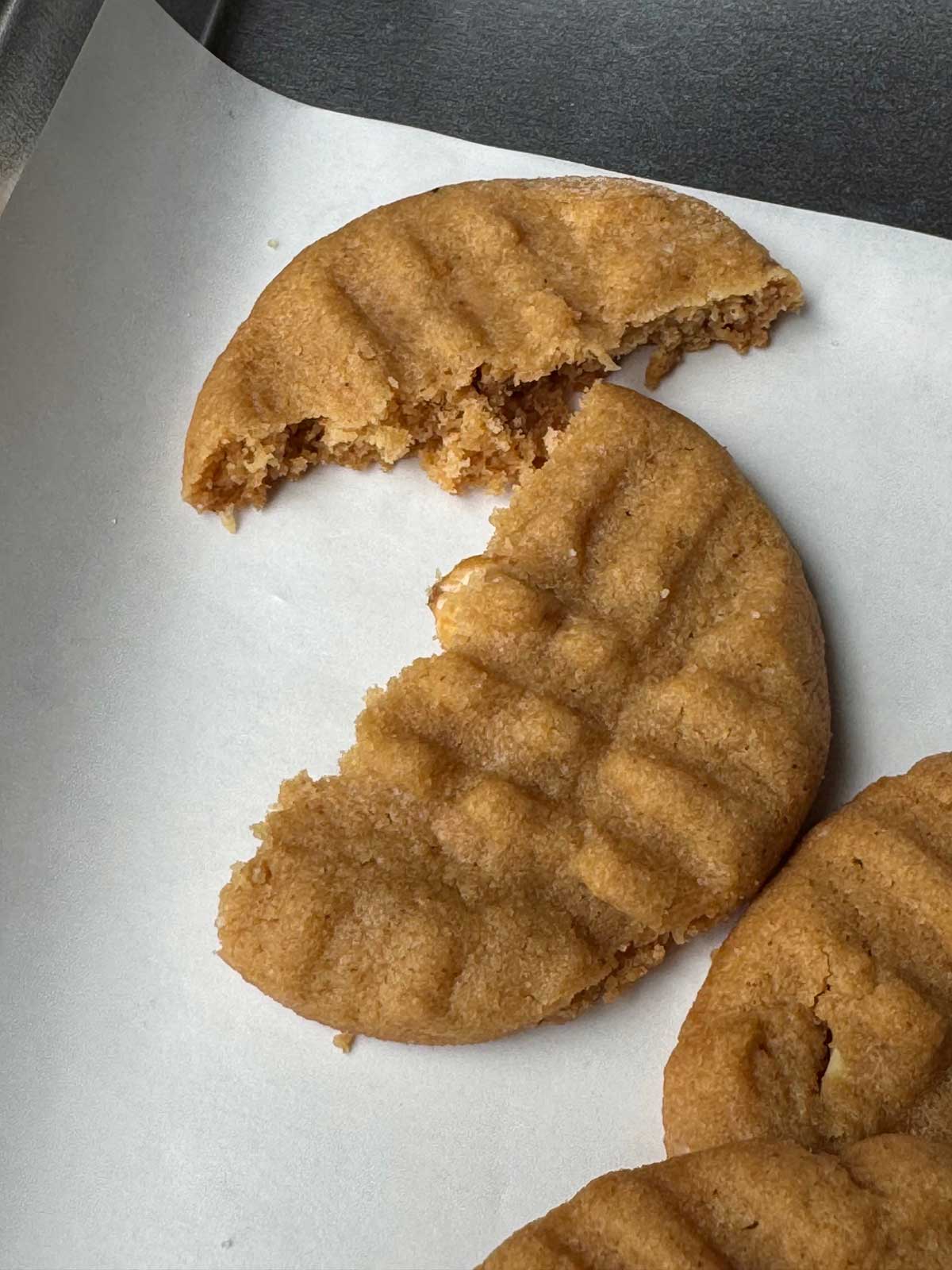 Broken thick & chewy peanut butter cookies showing texture.