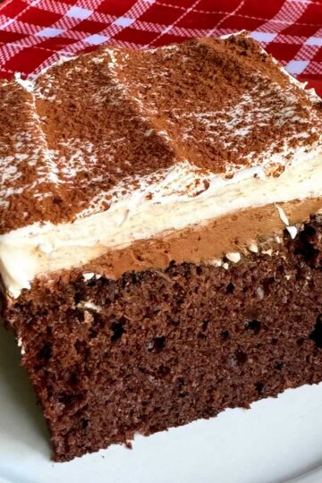 Wacky Cake or Depression Cake topped with chocolate ganache frosting and whipped cream.