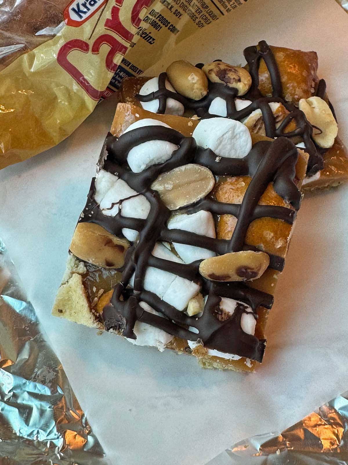 Kraft Caramel Crunch Bars recipe with a layer of graham crackers, melted Kraft caramel bits, marshmallows, peanuts, pretzels and chocolate.