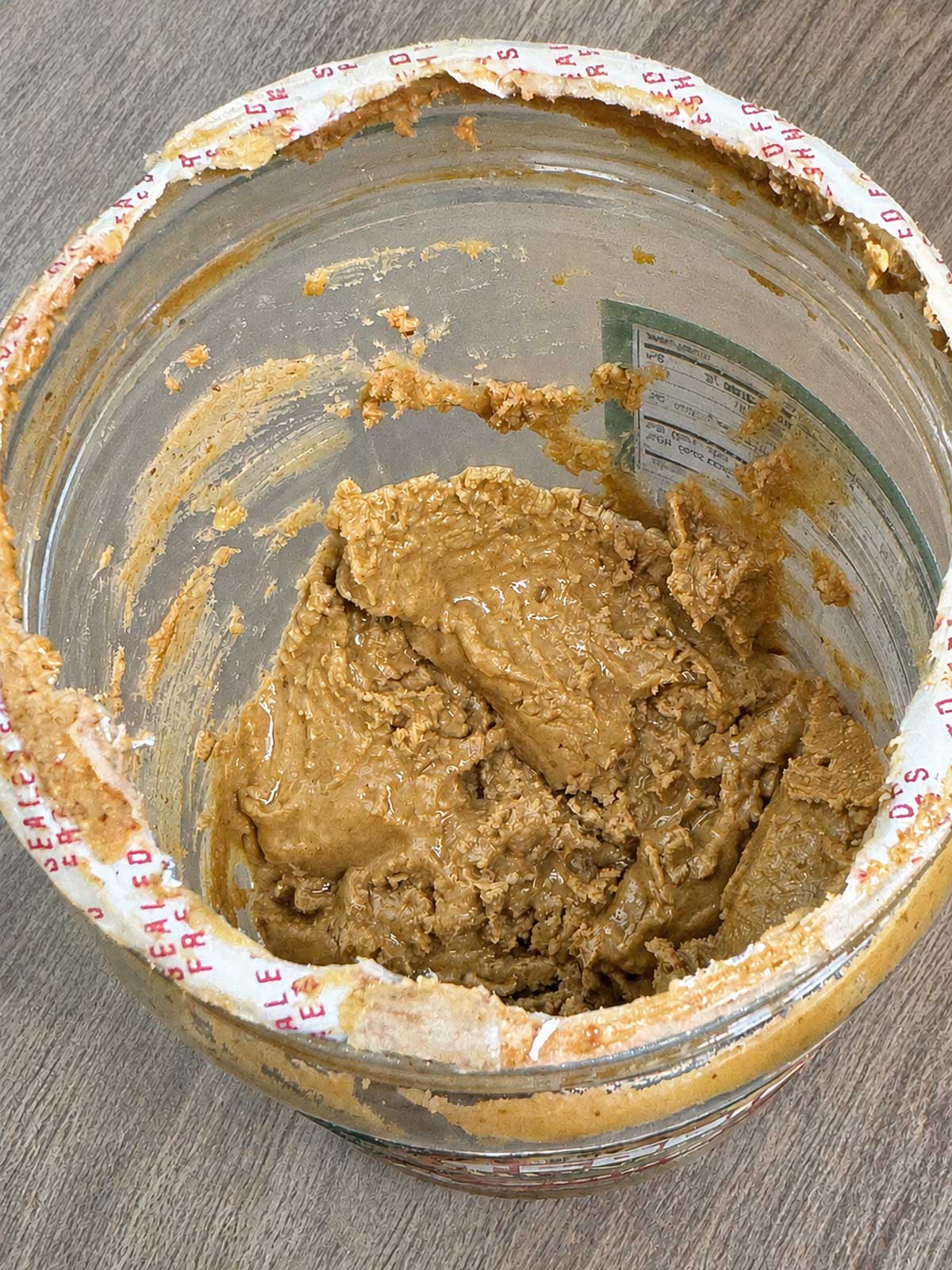Dregs of peanut butter at the bottom of the Teddie peanut butter jar.
