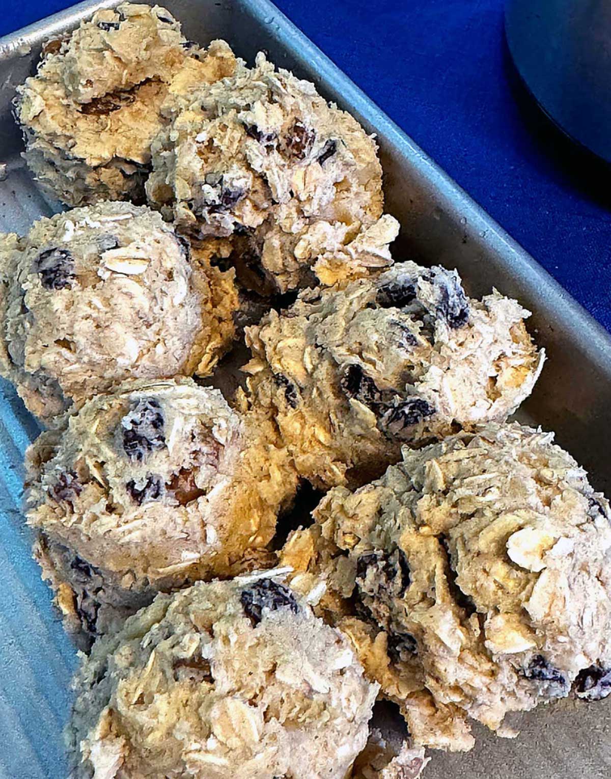 Scooped oatmeal cookie dough on a mini sheet pan.