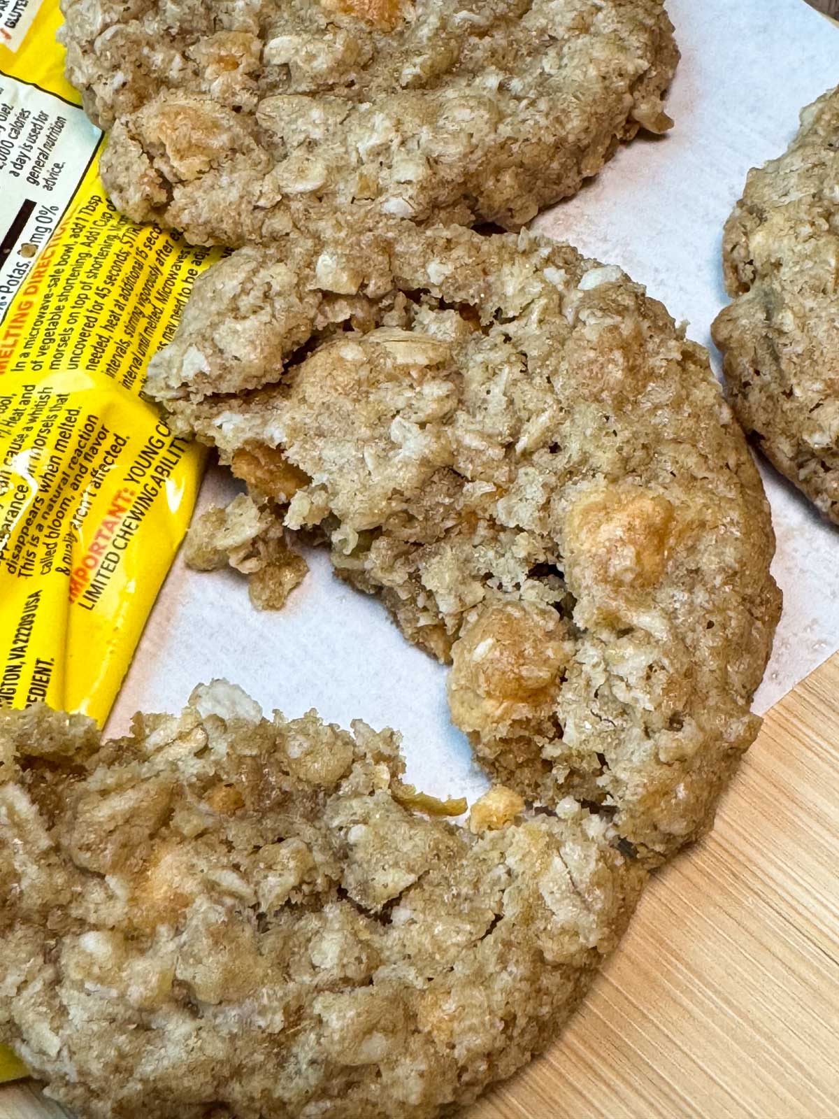 A thick and chewy oatmeal scotchies cookie broken to show texture.