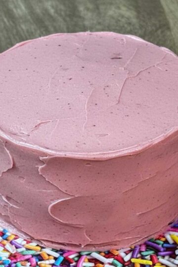 Strawberry layer cake made with enhanced strawberry cake mix and strawberry flavored cream cheese frosting with freeze dried strawberries.
