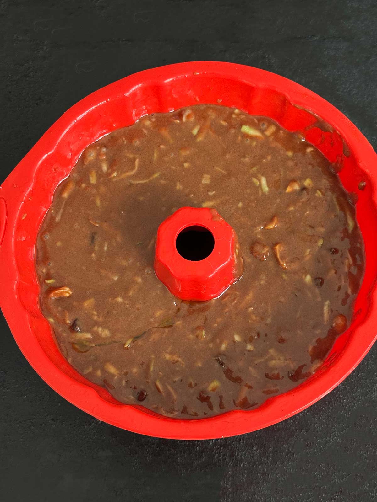 A 6-cup silicone Bundt pan filled with chocolate zucchini cake batter.