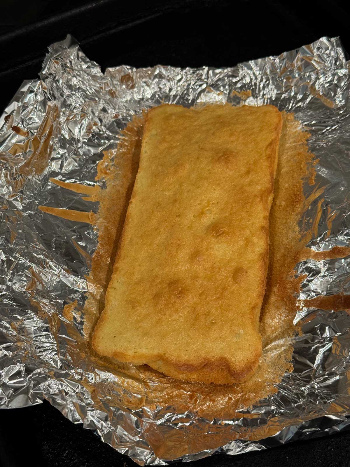 Olive oil sponge cake spread in a thin layer and baked in a foil lined loaf pan.