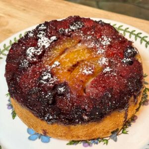 Olive Oil Upside Down Fruit Cake topped with mixed berries and peaches.