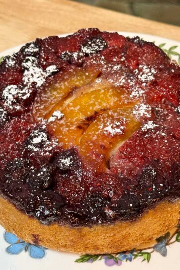 Olive Oil Upside Down Fruit Cake topped with mixed berries and peaches.
