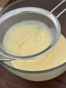 Strain the custard into a clean mixing bowl.