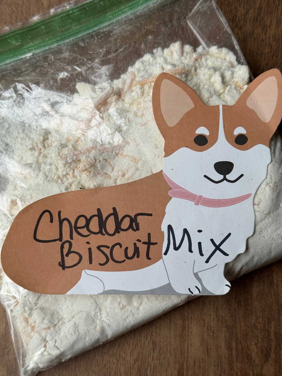 Homemade cheddar biscuit mix in a zipper bag with a corgi.