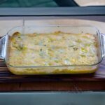 Cheesy Spinach Artichoke Squares baked in a glass dish.