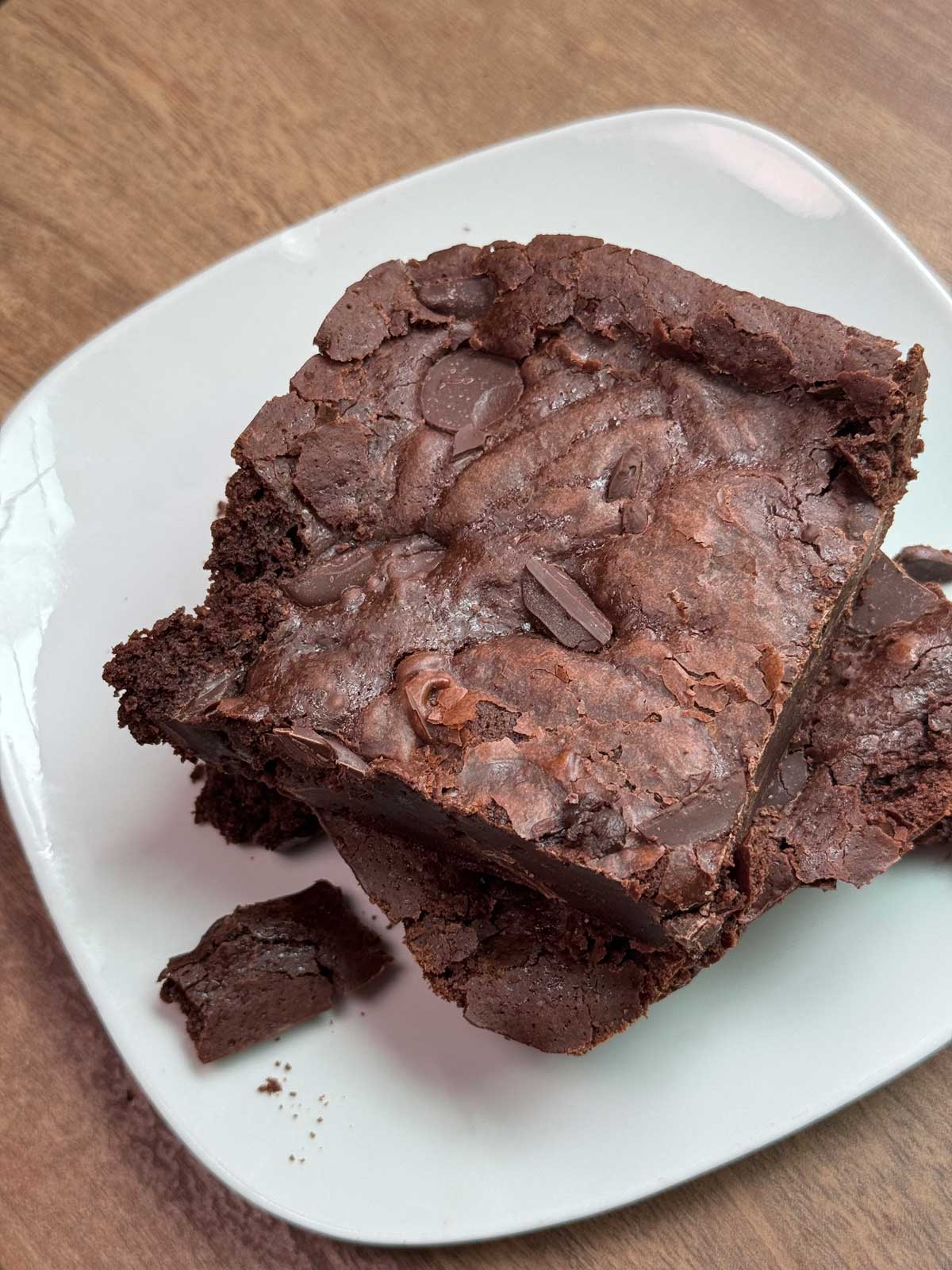 brownie-on-plate Fudgy brownies with crumbly edges baked in a glass dish.