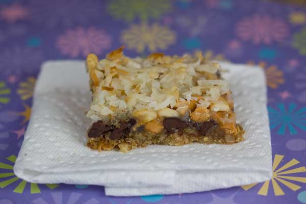 Pretzel Crust Seven Layer Bars topped with a mixture of cream, sugar, chocolate and butterscotch chips and cashews.