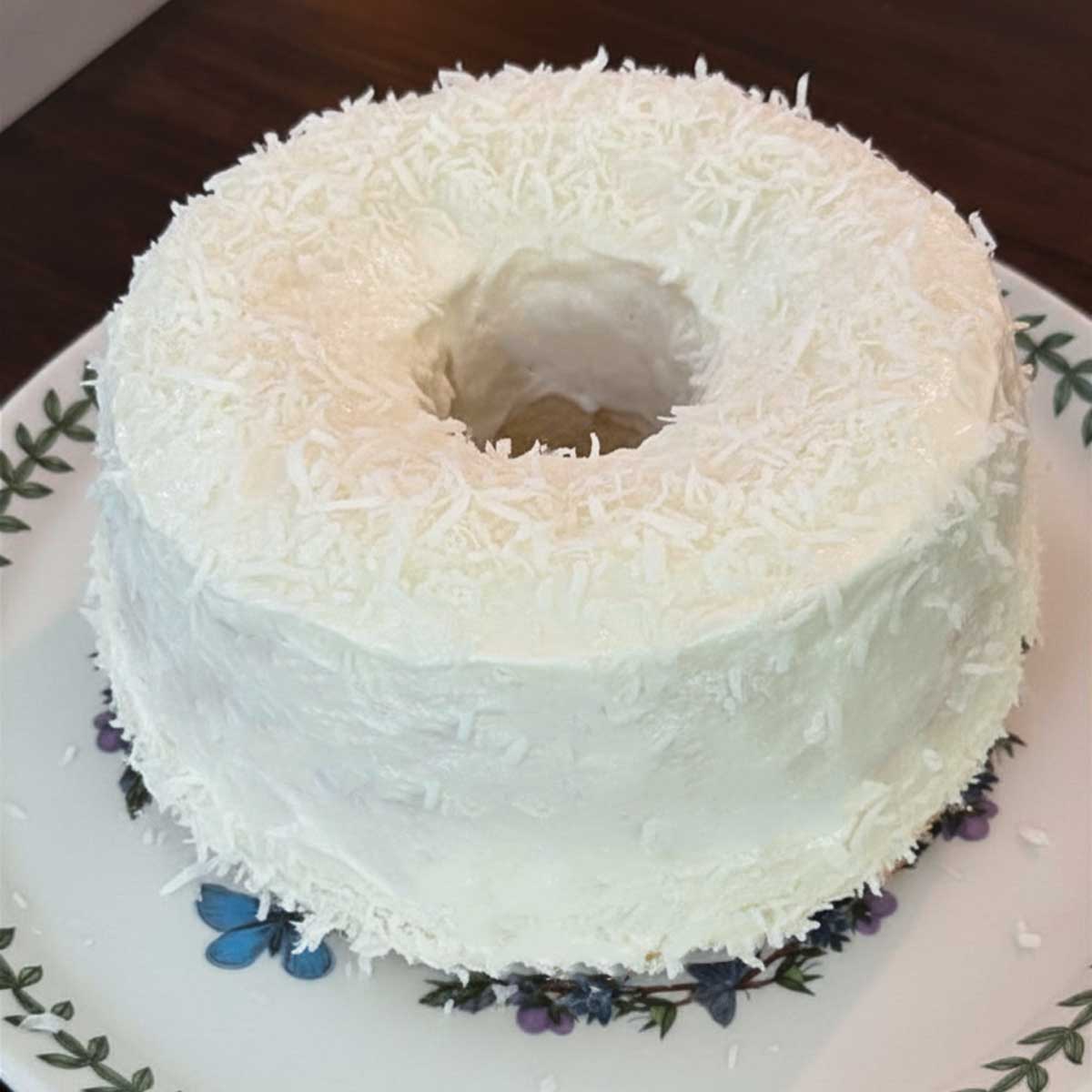 An angel food cake aka Coconut Cloud Cake baked in a 7-inch tube pan.