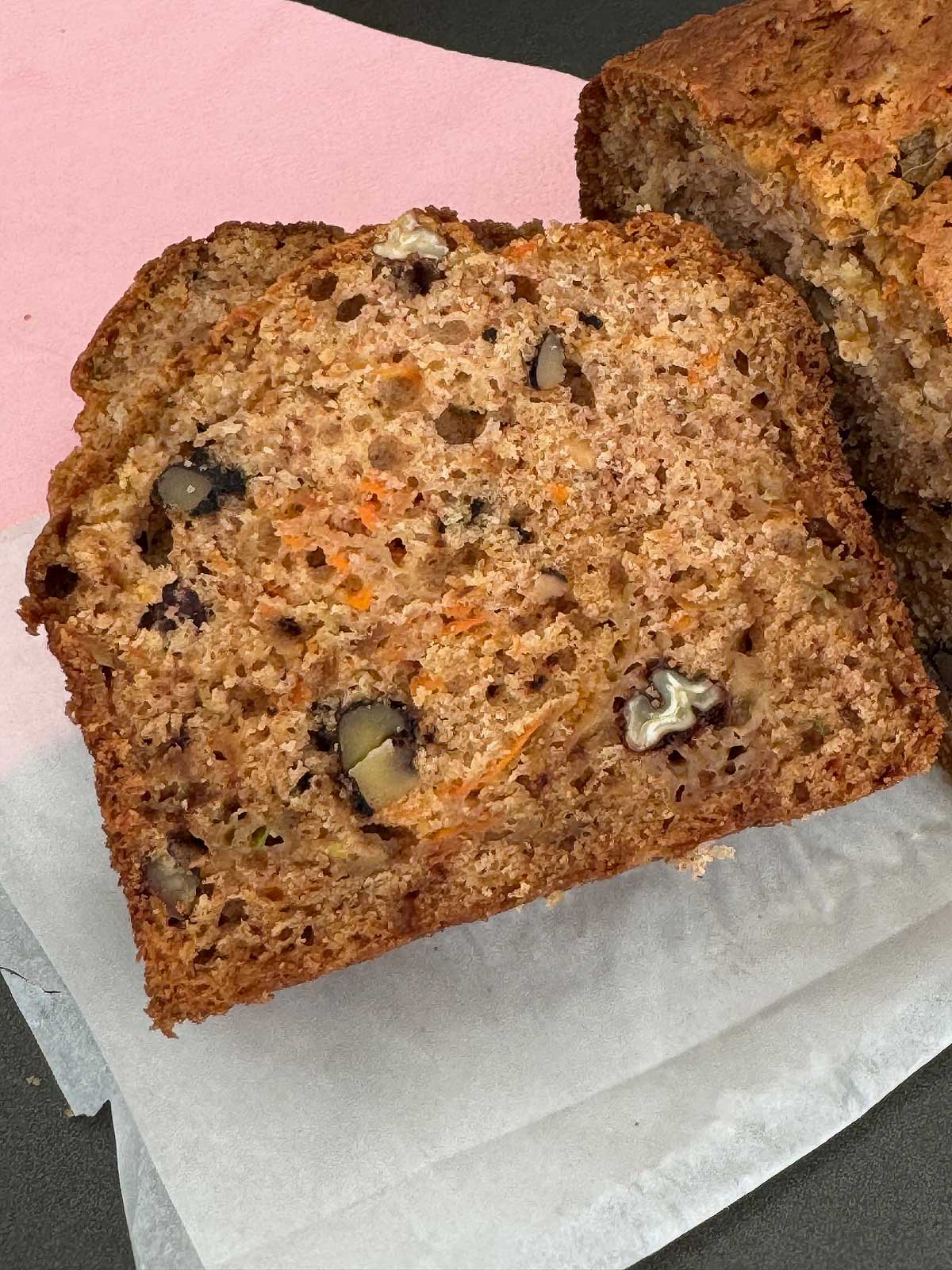 Slice of Sourdough Zucchini Bread showing crumb, carrots and apples.