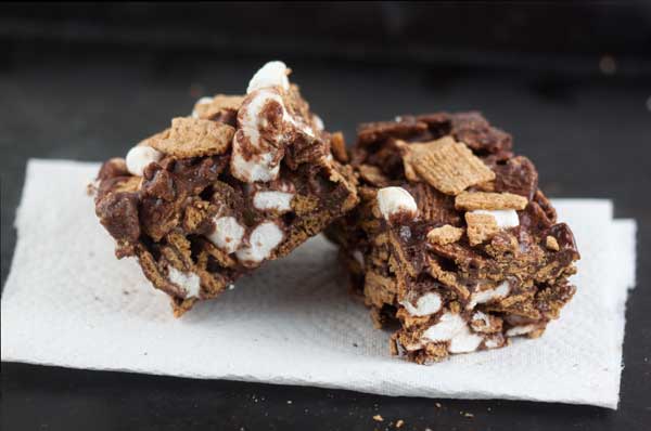Golden Grahams S'mores Bars on a paper towel with a black background.