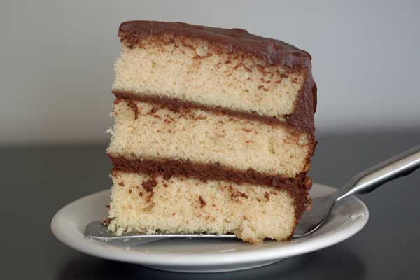 A slice of three layer yellow cake from Jocelyn Delk Adams' cookbook.