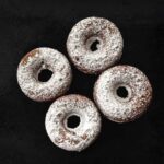 Baked donuts with powdered sugar sprinkled all over.