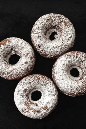 Baked donuts with powdered sugar sprinkled all over.