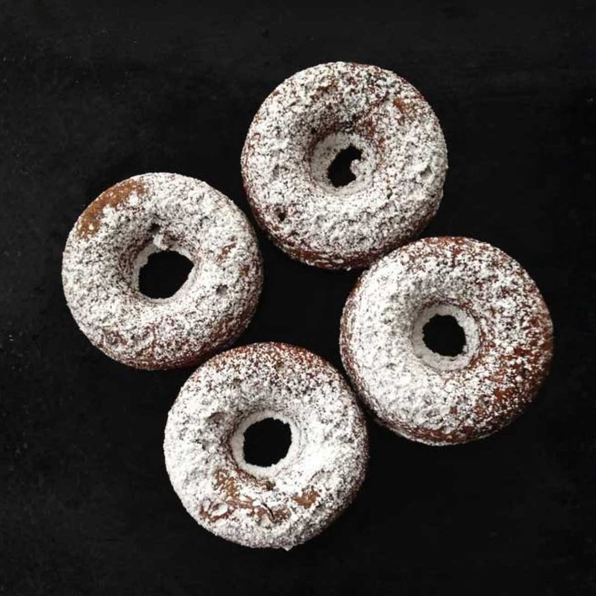 Baked donuts with powdered sugar sprinkled all over.
