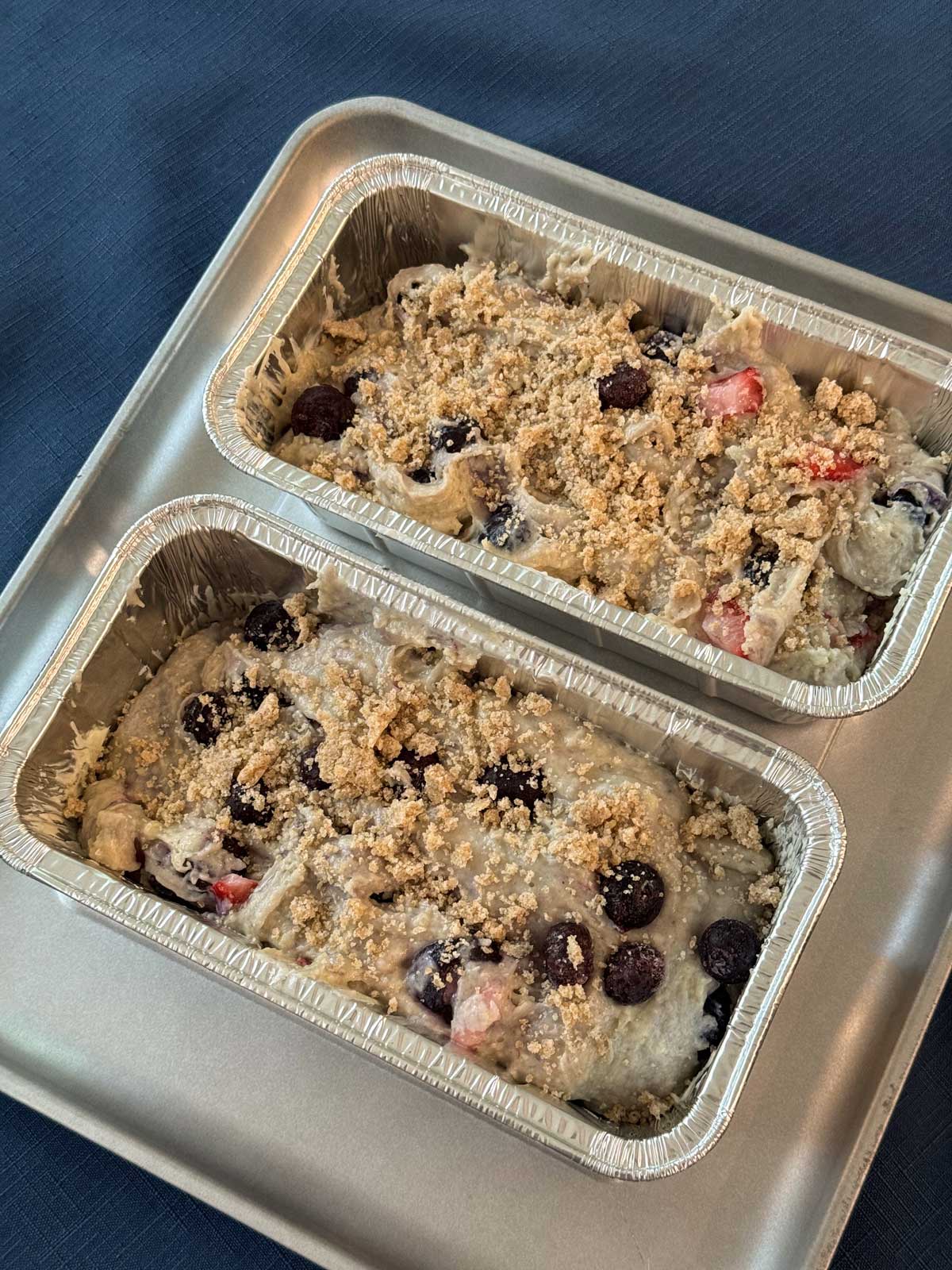 Flo Braker's Blackberry Yogurt Loaf made with frozen blueberries and strawberries and divided between two disposable loaf pans.