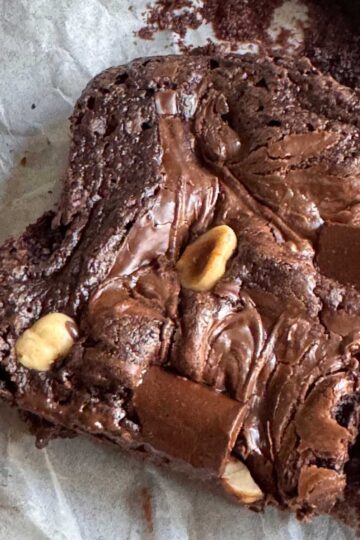 Hazelnut brownies made with oil, topped with nuts and swirled with Nutella