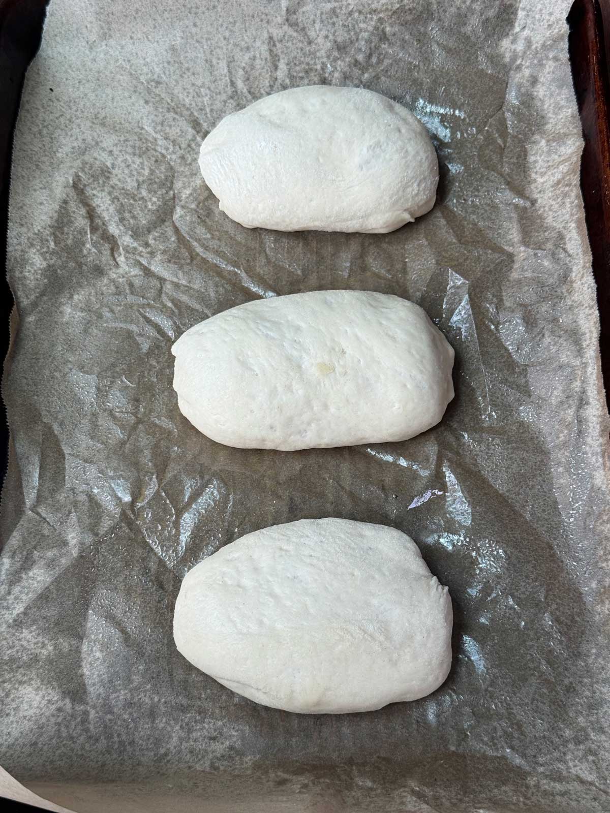 Unbaked pretzel bun dough shaped as oblongs