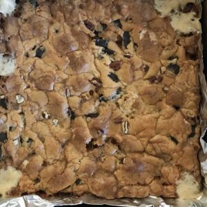 8-inch square pan of Chewy Marshmallow Blondies with melted butterscotch chips and mini marshmallows in the dough.