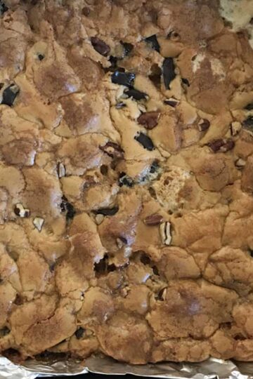 8-inch square pan of Chewy Marshmallow Blondies with melted butterscotch chips and mini marshmallows in the dough.