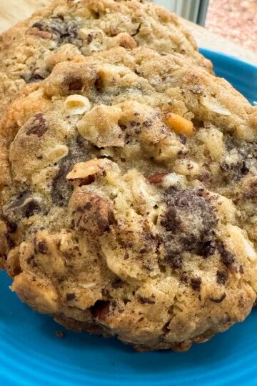 Thick Almond Chocolate Chunk Cookies on a blue plate showing nutty texture.