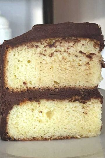 A slice of Six Inch Yellow with Chocolate Frosting with two layers.