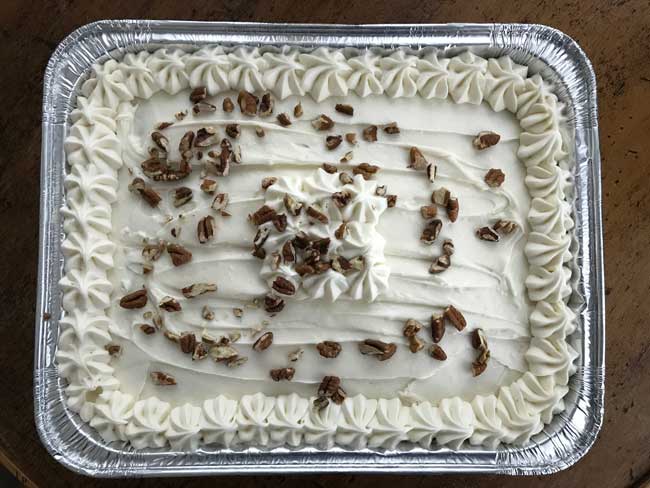 Buttermilk Glazed Carrot Cake in a disposable pan with a fluffy not too cheesy cream cheese frosting.