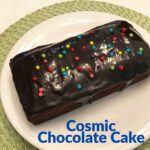 Cosmic Chocolate Cake, a brown sugar chocolate loaf cake wit h a glossy glaze and sprinkles.