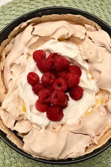 Pavlova filled with lemon curd, whipped cream and fresh berries using a very easy recipe.