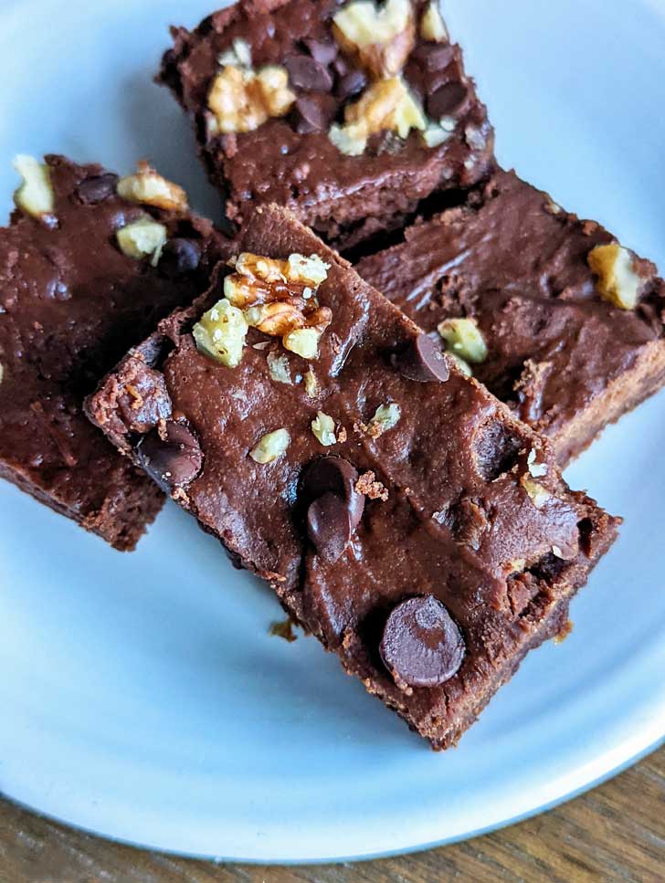 Greek yogurt brownies cut into rectangles sitting on a plate.