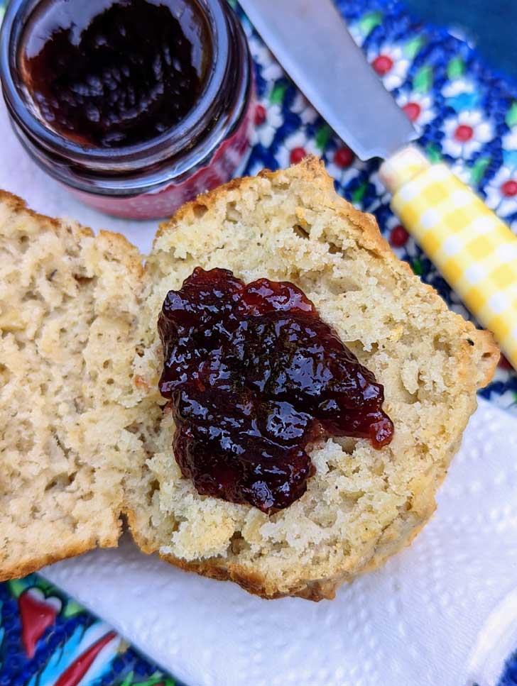 Cooked Oatmeal Muffin pictured on a plate, split, and with jelly.