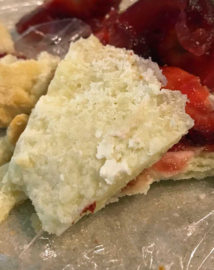 Close-up of a baked gluten-free pie crust showing how flaky it is.