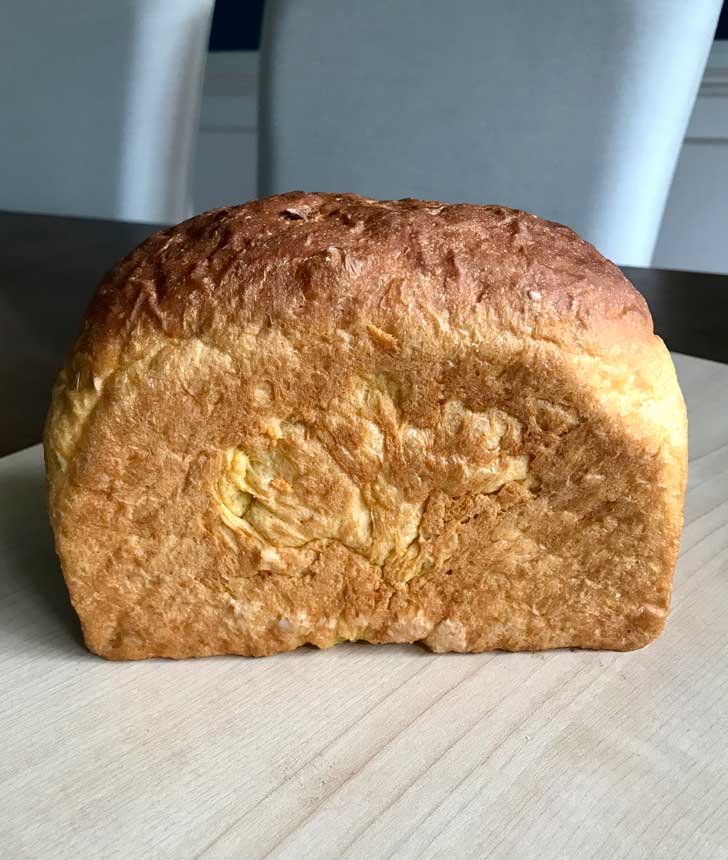 Yeast bread made with sweet potatoes sitting on a cutting board.