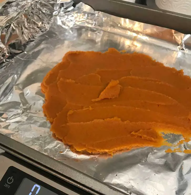Making roasted canned pumpkin by spreading it on a foil lined baking sheet.