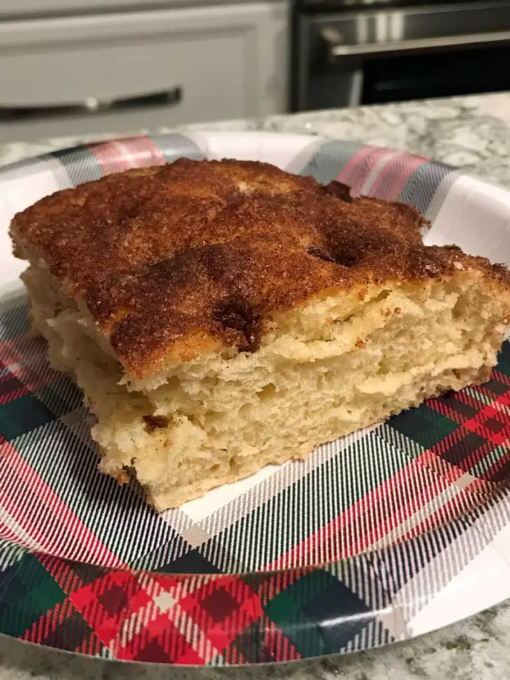 Square of Moravian Sugar Cake on a Christmas paper plate.