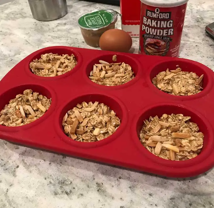 Unbaked oatmeal in a six cup silicone muffin pan.