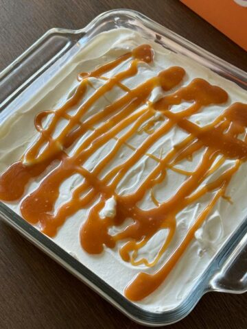 angel food cake bavarian in an 8-inch square dish with caramel sauce on it.