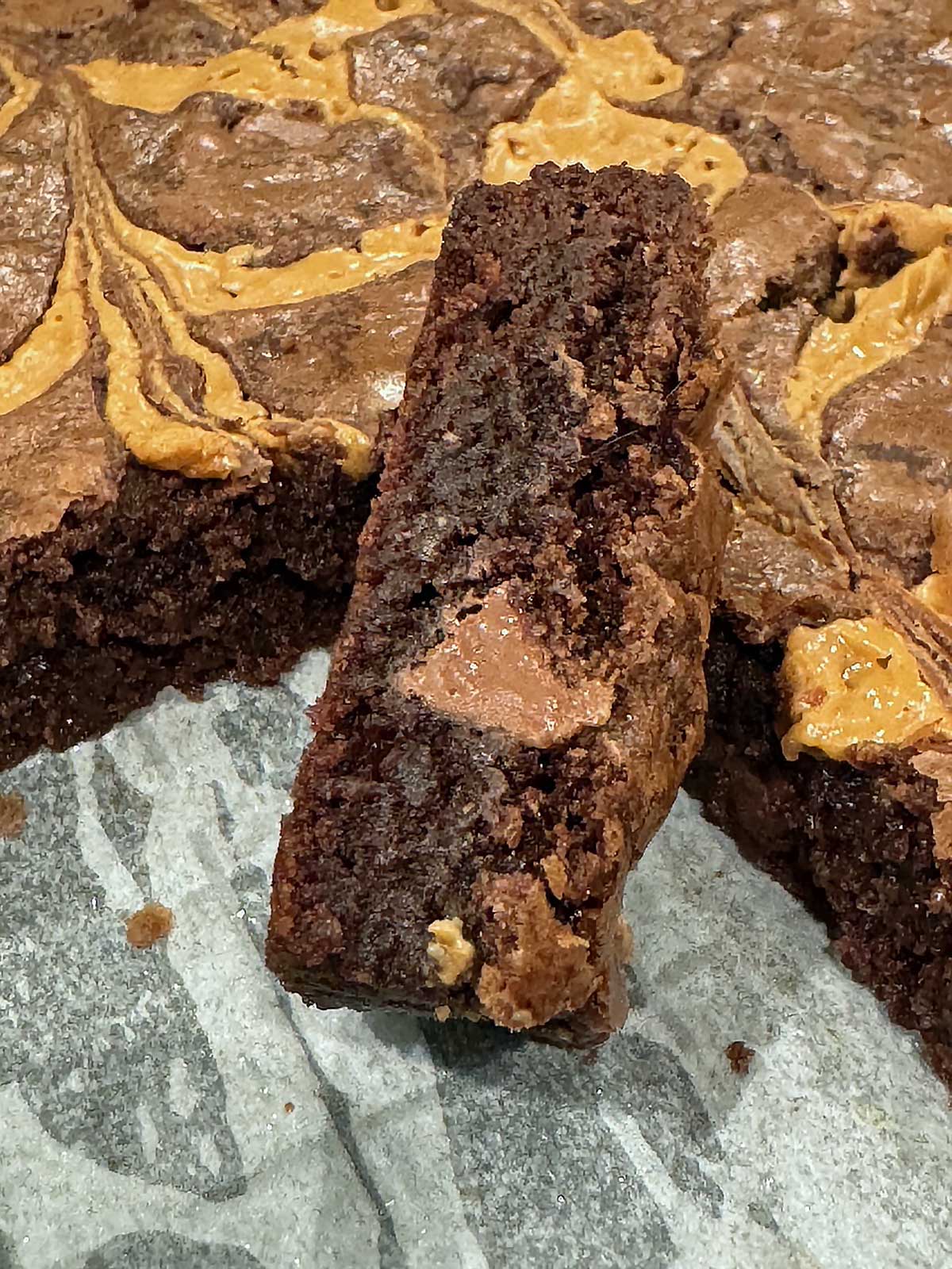 Slice of milk chocolate brownie with a big milk chocolate chip in the cross-section.
