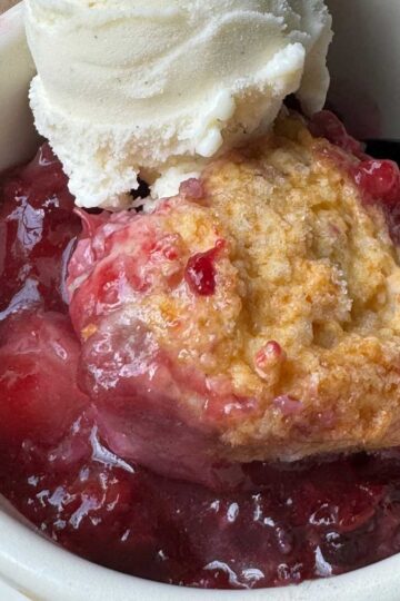 Quick Blackberry Cobbler in a bowl with vanilla ice cream.