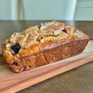 Blackberry Quick Bread that was baked in a Pampered Chef stoneware loaf pan and has a shiny top.
