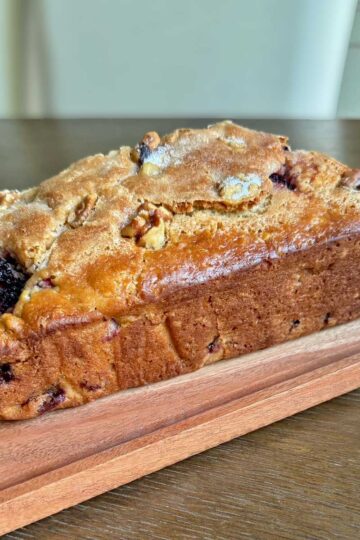 Blackberry Quick Bread that was baked in a Pampered Chef stoneware loaf pan and has a shiny top.