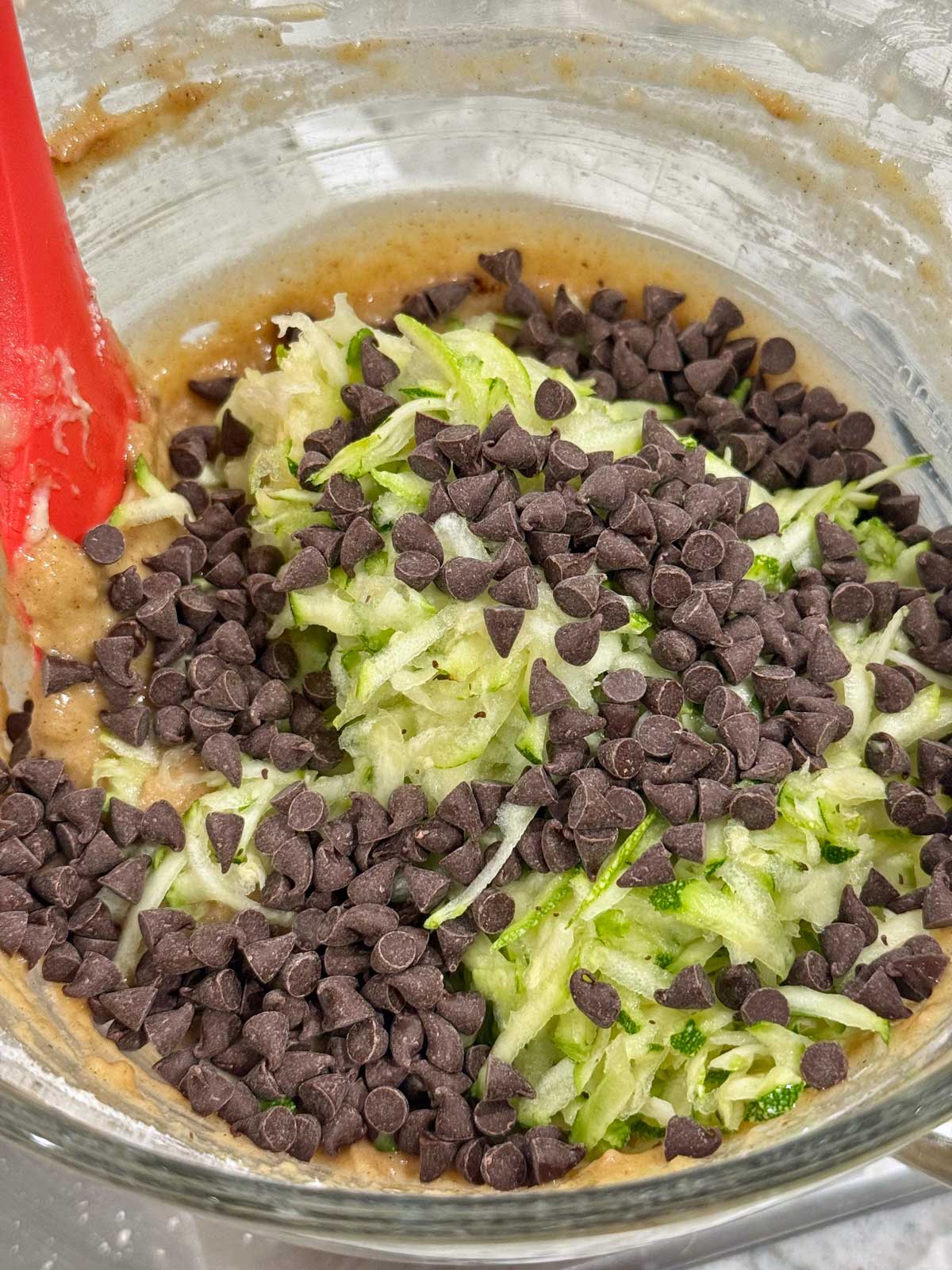 Gluten-Free Chocolate Chip Zucchini Bread batter showing zucchini shreds.