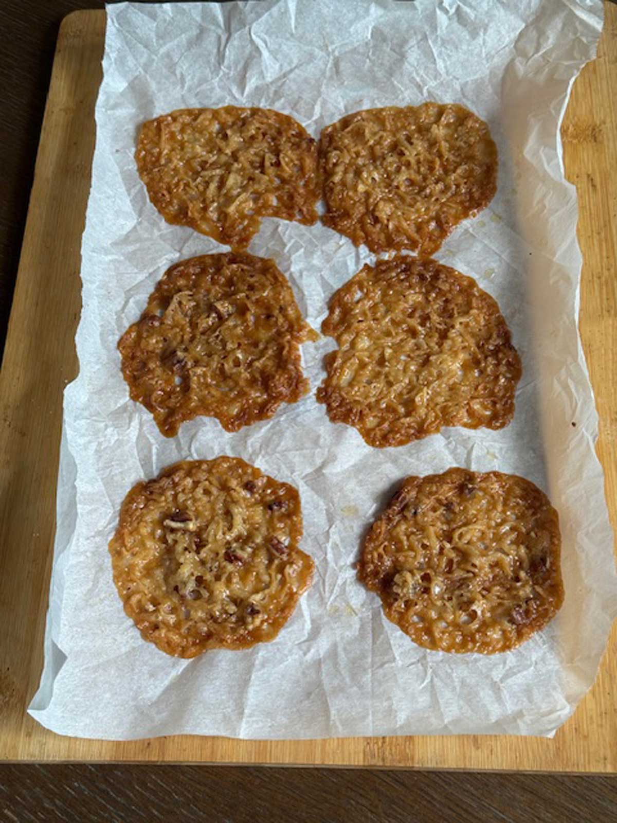 Lady Bird Johnson's Lace Cookies cooling on a sheet of parchment paper.