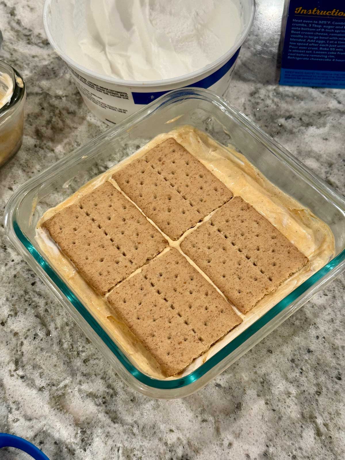 An eclair cake being assembled.