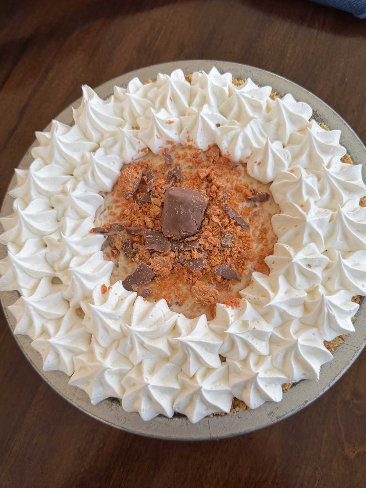 Butterfinger Pie made with fresh whipped cream, cream cheese and a browned butter Ritz cracker crust.