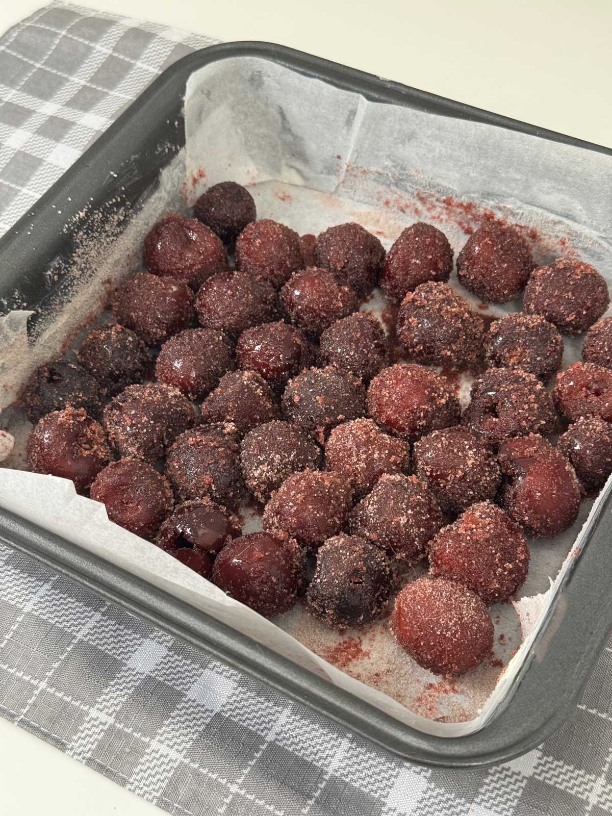 Frozen cherries in an 8-inch square pan to be made into a Cha-Cha-Cha Cherry Cake.